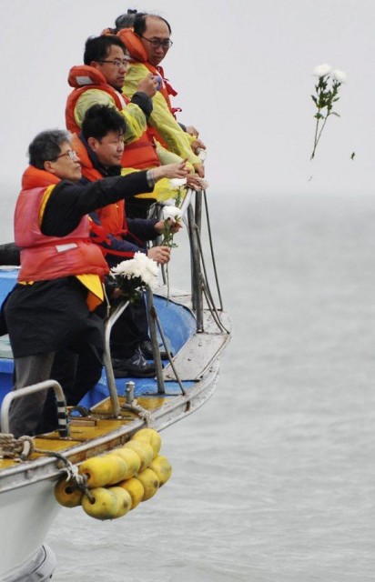 Family members throw flowers in tribute to ferry Sewol sinking victims